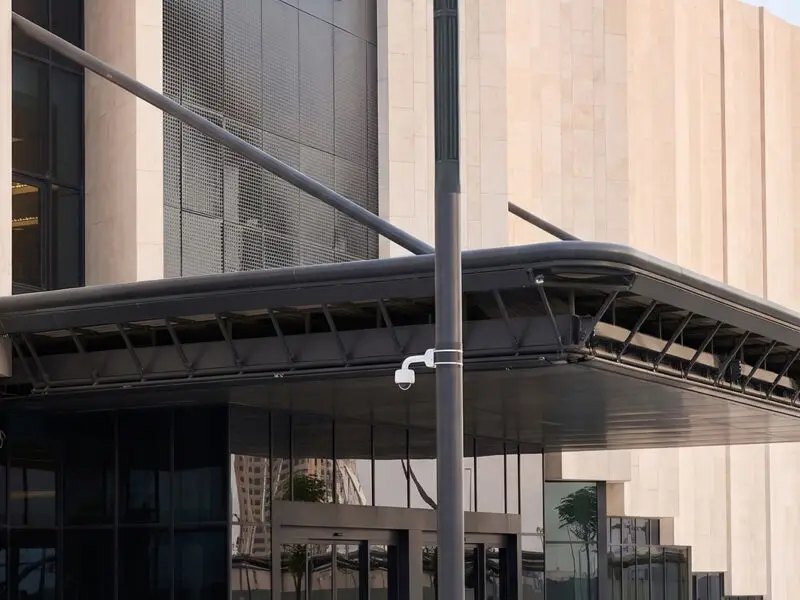 Etihad Rail smart city lighting infrastructure: OptoSmart modern solar poles installed alongside mountainous highway and the central train station building.