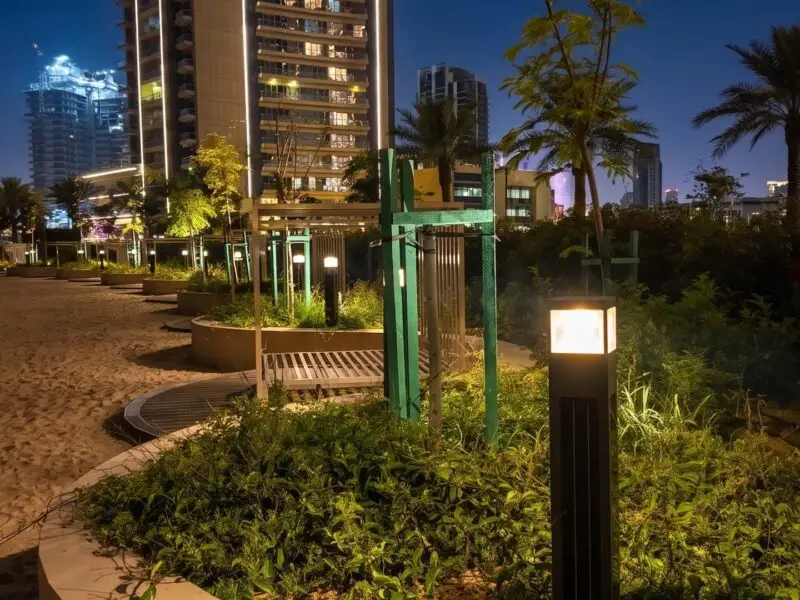 Square solar bollard providing off-grid LED illumination for a modern landscape in the Qatar park project.